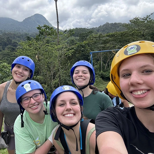 Arcadia students wear helmets as part of a group activity in a tropical destination.