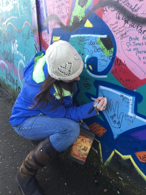Allison Harpole signing the Peace Wall.