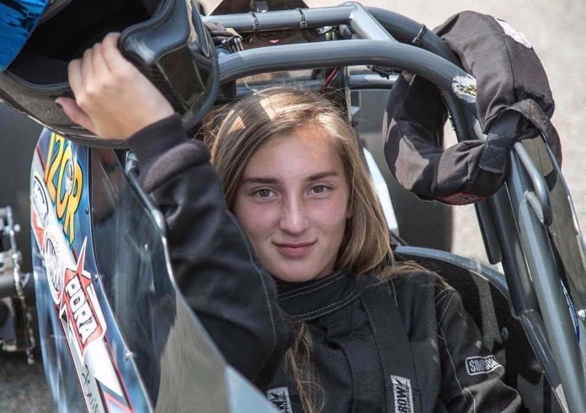 Arcadia University student Bailie Zepp takes off her helmet in her race car.