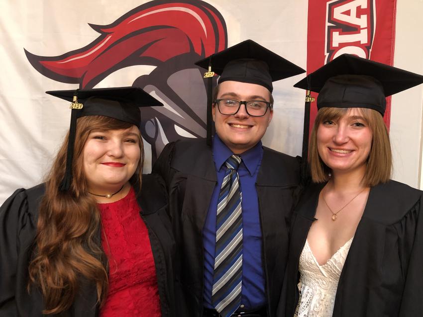 (Left to right) Tori, Ed, and Kate Knab in graduation robes and caps.