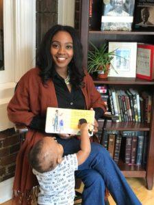 Lisa Browne holding a book and playing with her toddler son