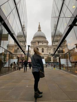 A woman stands looking at St. Paul's Cathedral dome in London, England