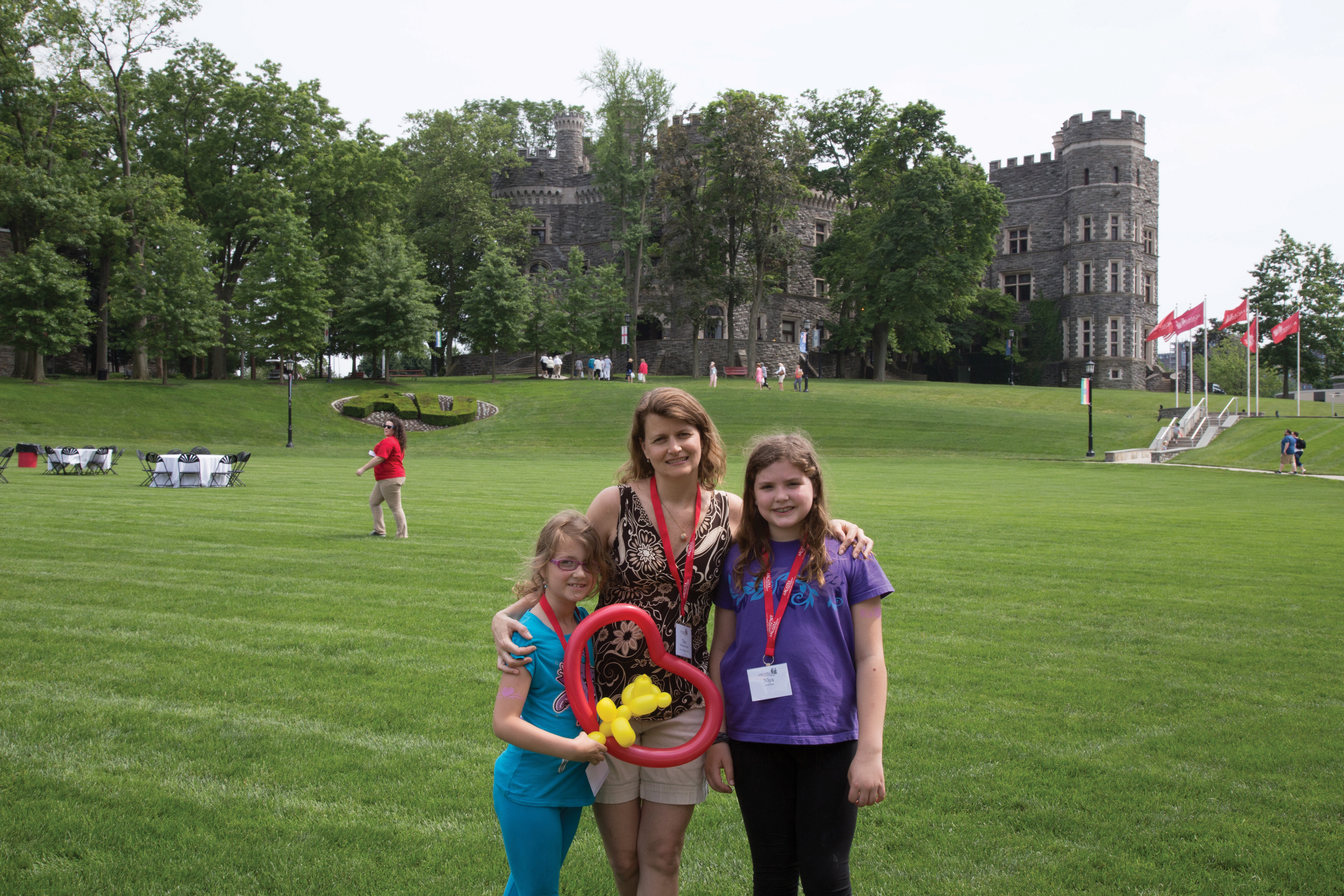 Female Alumni student posing with her two daughters on Haber Green.