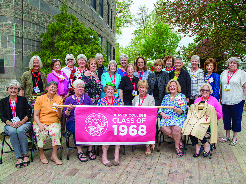 A group of senior female alumni students holding a Beaver College Class of 1968 banner.