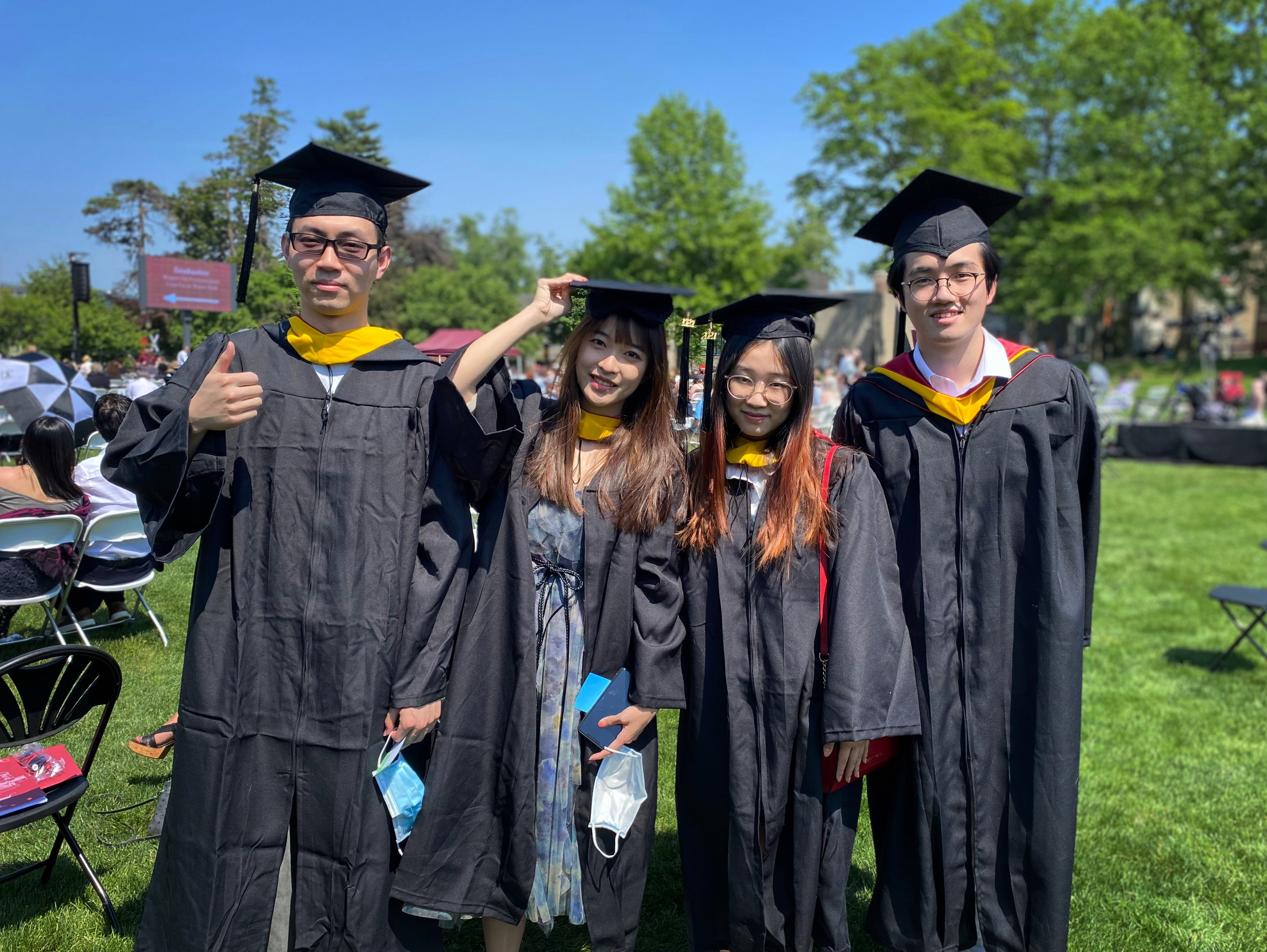 Four graduating Asian students posing together.