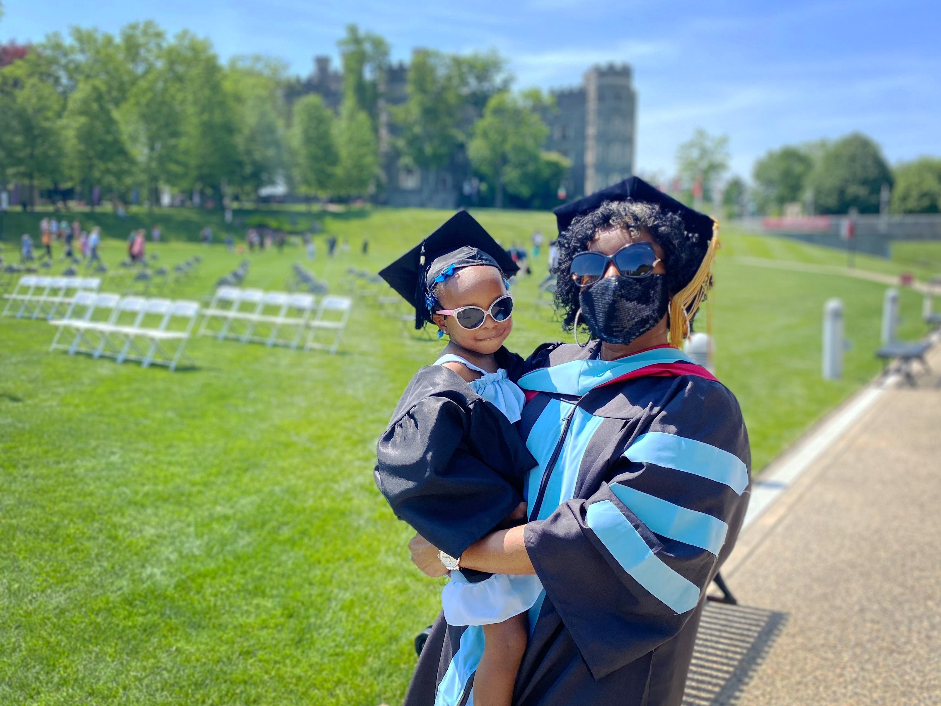 A graduating Doctorate student posing with her toddler.