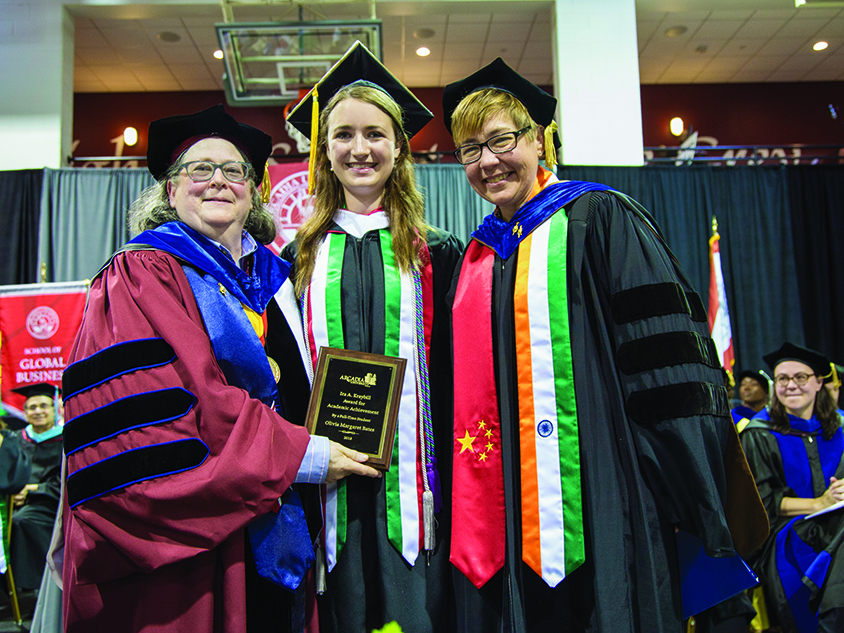 Olivia Bates with her award and posing with two other faculty members.