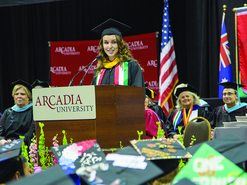 Graduating female student talking at the podium.