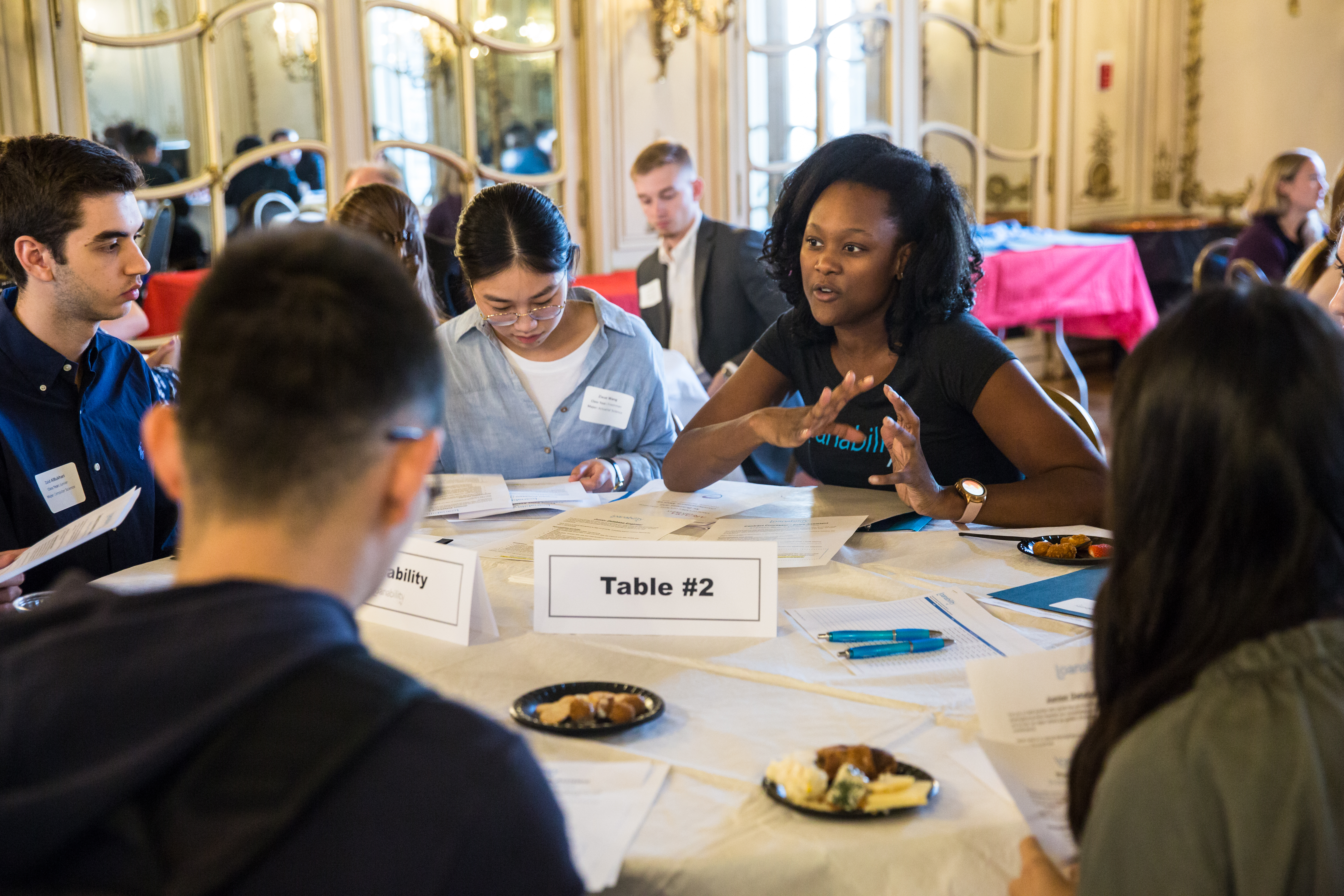 Several students at a table networking.