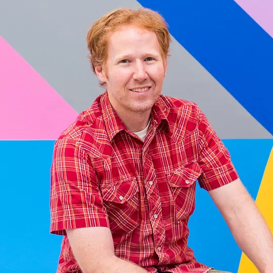 David Guinn sits in front of a mural