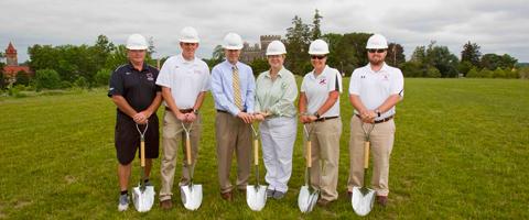 Six people holding shovels in the ground