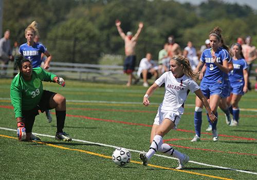 A member of the Arcadia women's soccer team kicks the ball during a game against Cabrini