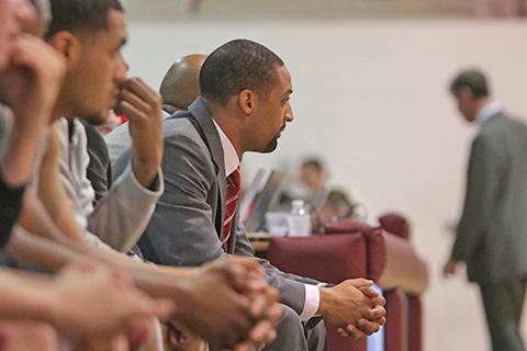 Arcadia's men's head basketball coach watches the game from the sideline