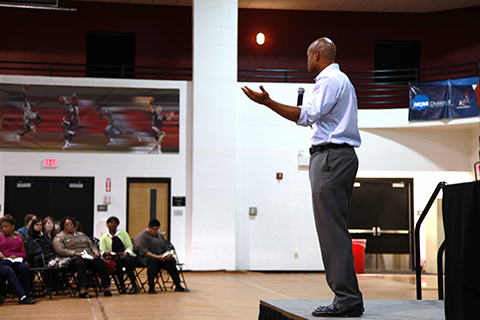 A person giving a speech in the gym.