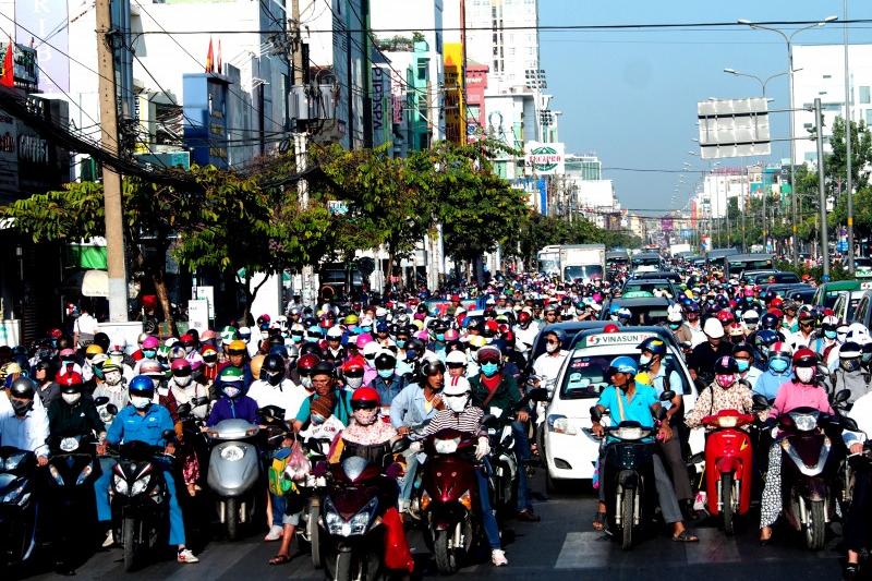 A busy street with a lot of people on motorbikes.