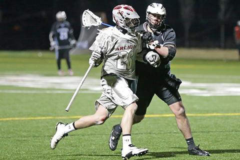Two lacrosse players playing on the field.