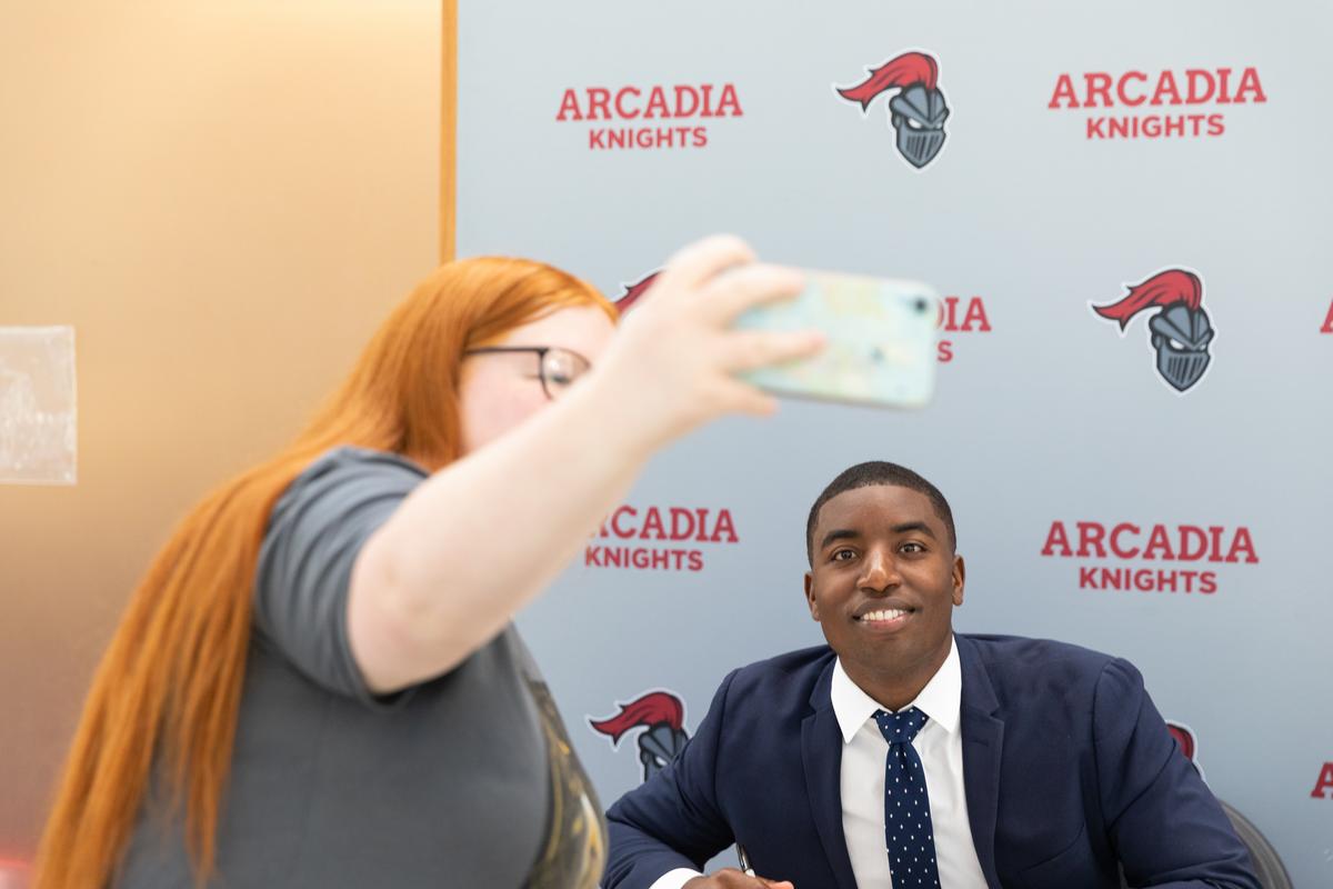 Kareem Rosser takes a selfie with a student during a book signing on campus. 