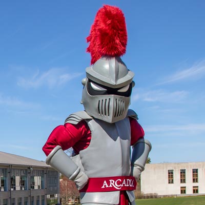 The Knight mascot for Arcadia University outside on a sunny day.