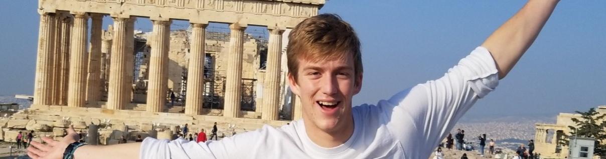 A student posing with old architecture from Greece.