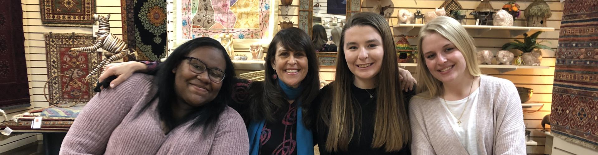 Four women posing together in an antique store