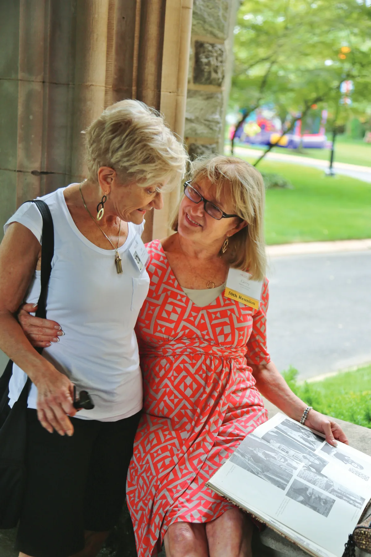 Two alumni from the Class of 1965 looking through the yearbook