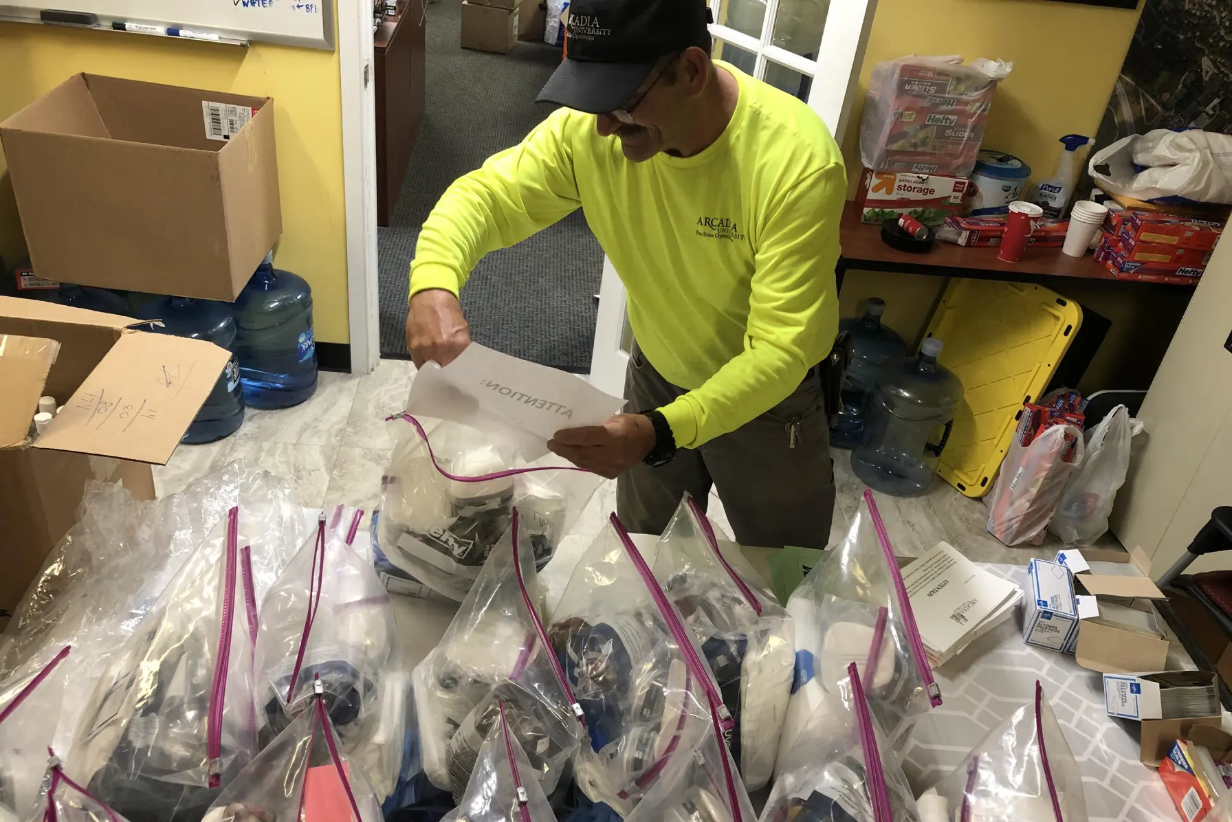 Facilities, Maintenance, and Housekeeping team member packing PPE kits.