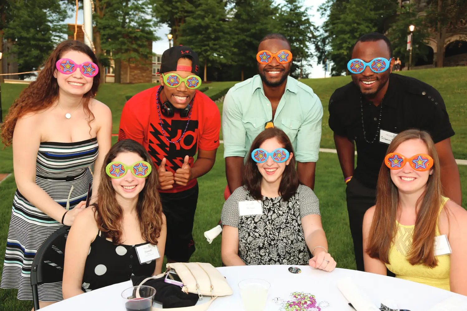 Several alumni students wearing colorful funny glasses during the picnic