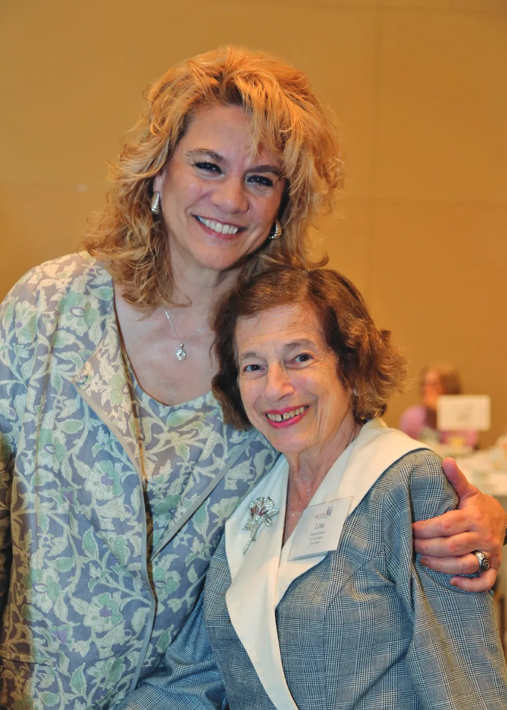 A person hugging and posing with Lois Hinlein Hirsch