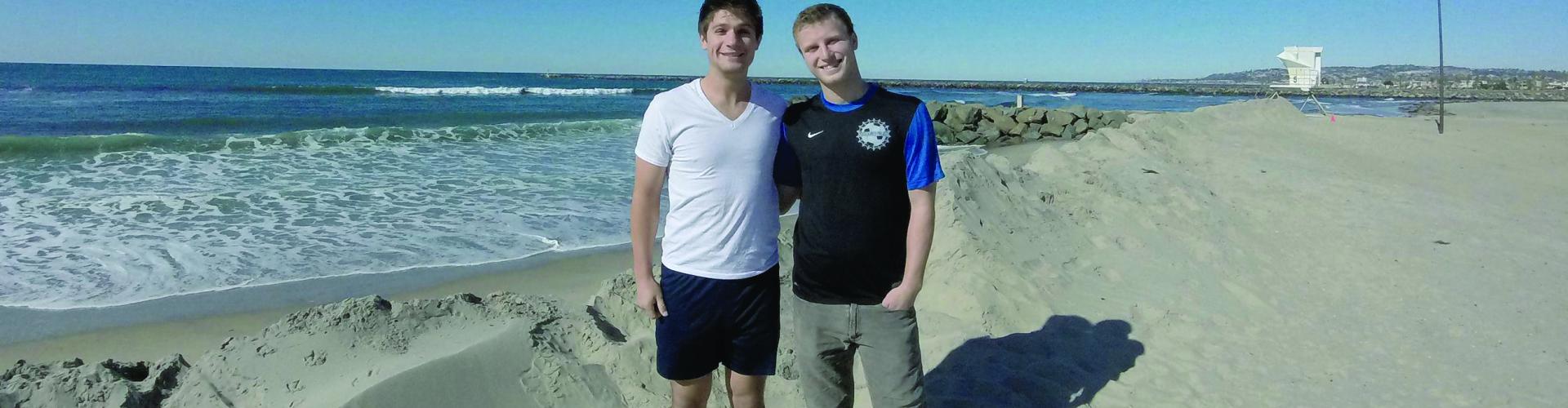 two male students posing at the beach