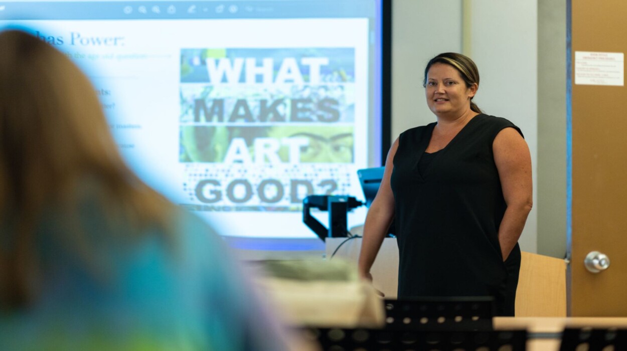 Art education teacher standing in front of class presenting a power point