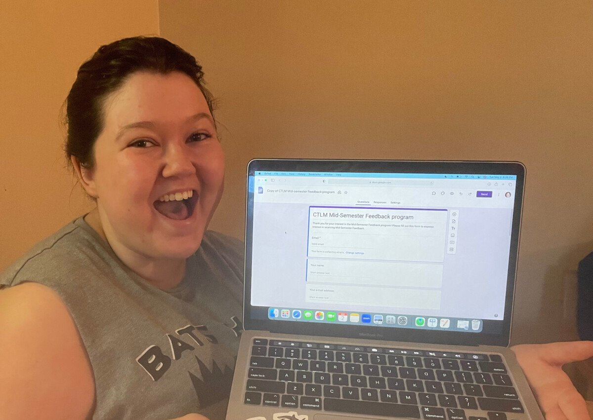 Jo Creollo '24 holds a laptop open to the CTLMmid-semester feedback form