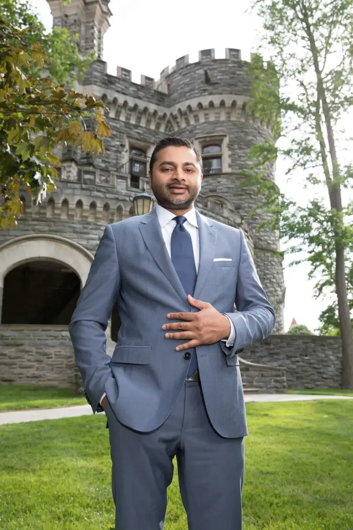 AJAY NAIR, PH.D., PRESIDENT stands outside of the castle on Arcadia's campus.