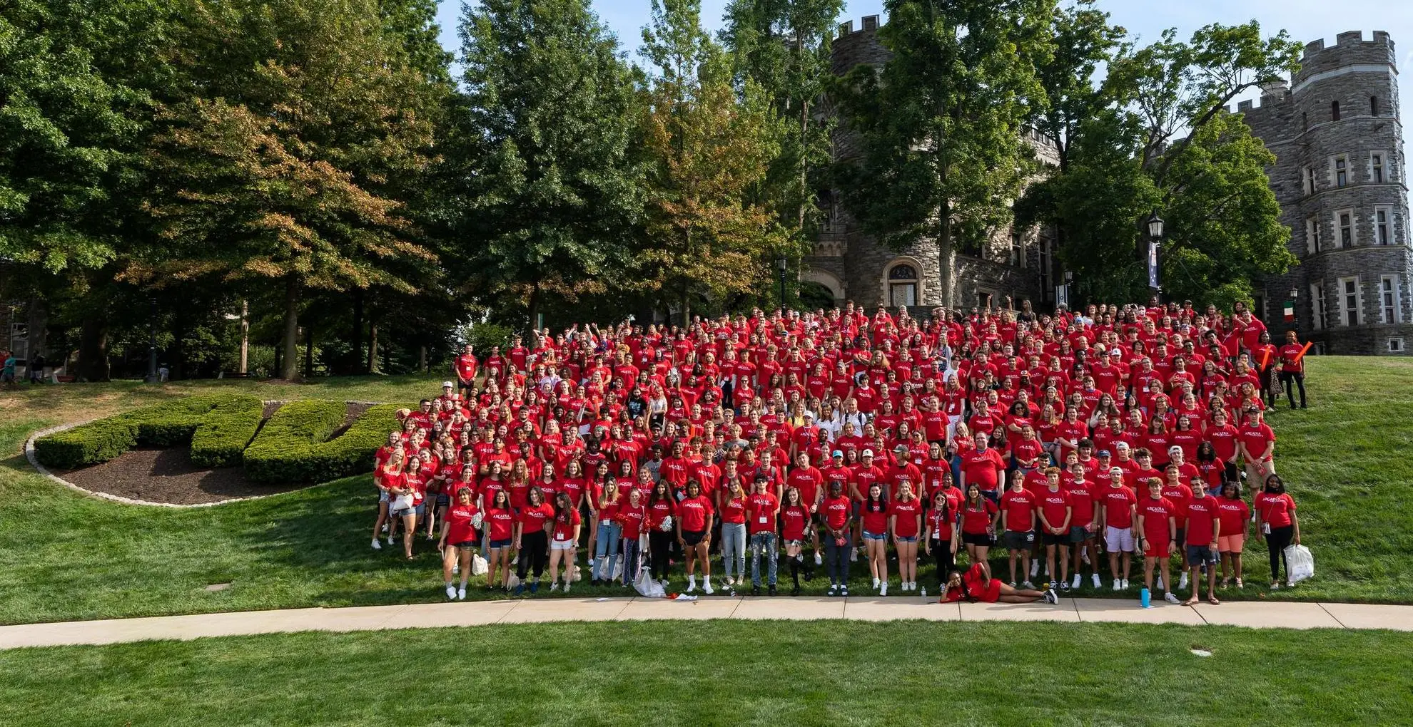A sea of red forms from a large group of students standing together outside.