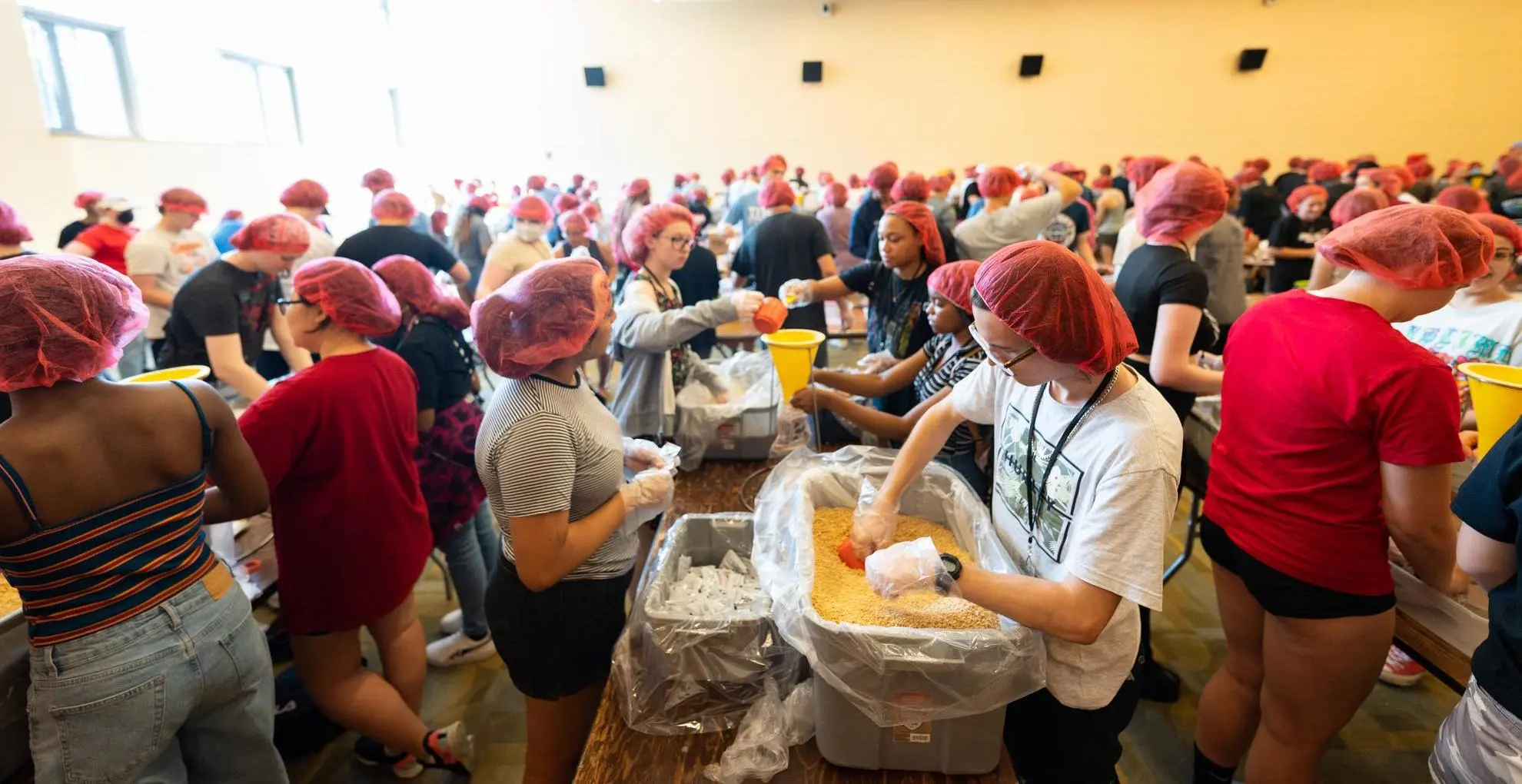 Arcadia students volunteer in a crowded kitchen for rise against hunger.