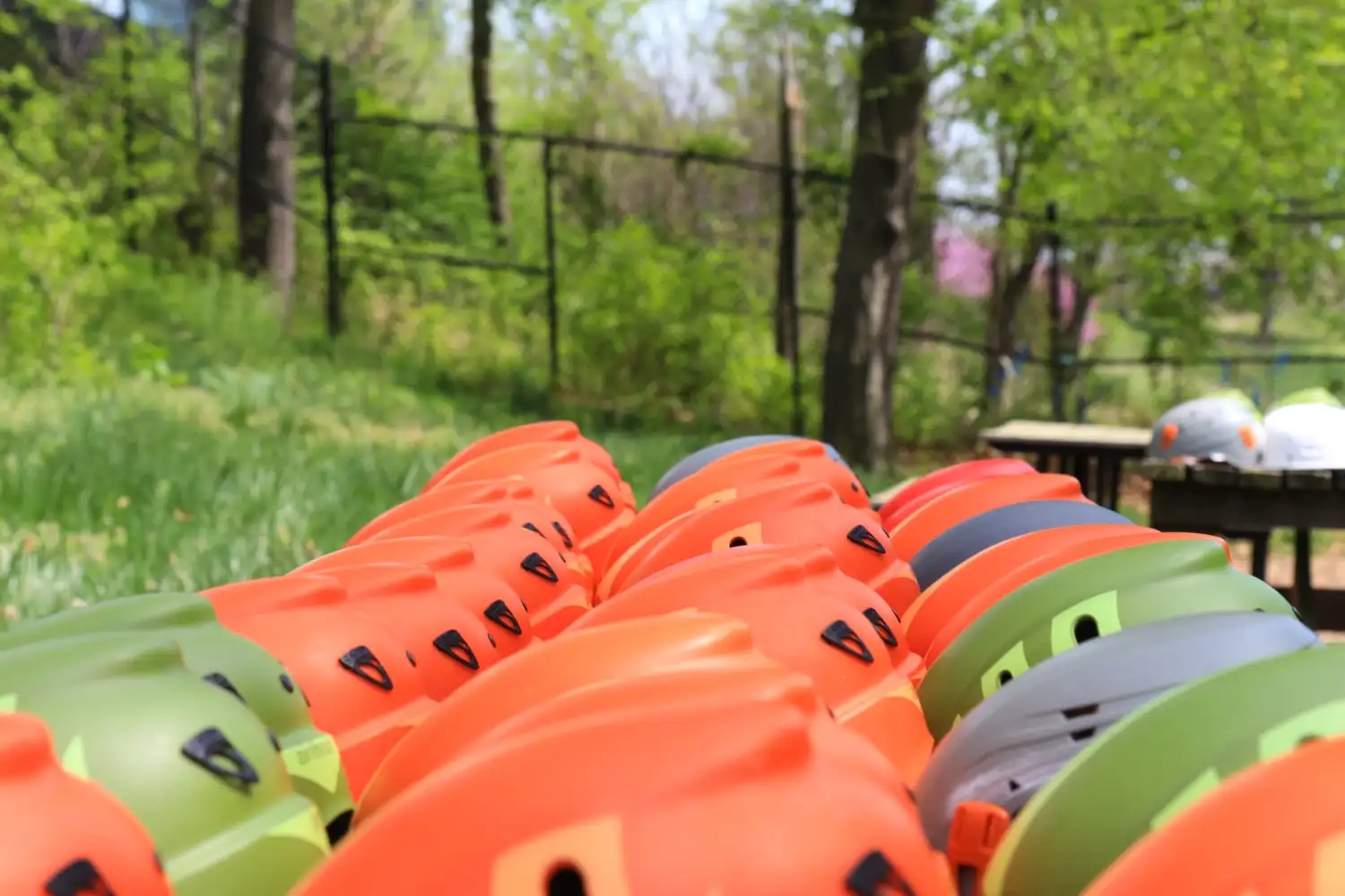 row of orange kayaks in the woods