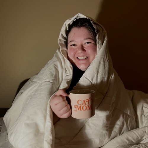 Jo bundled up with a warm drink.