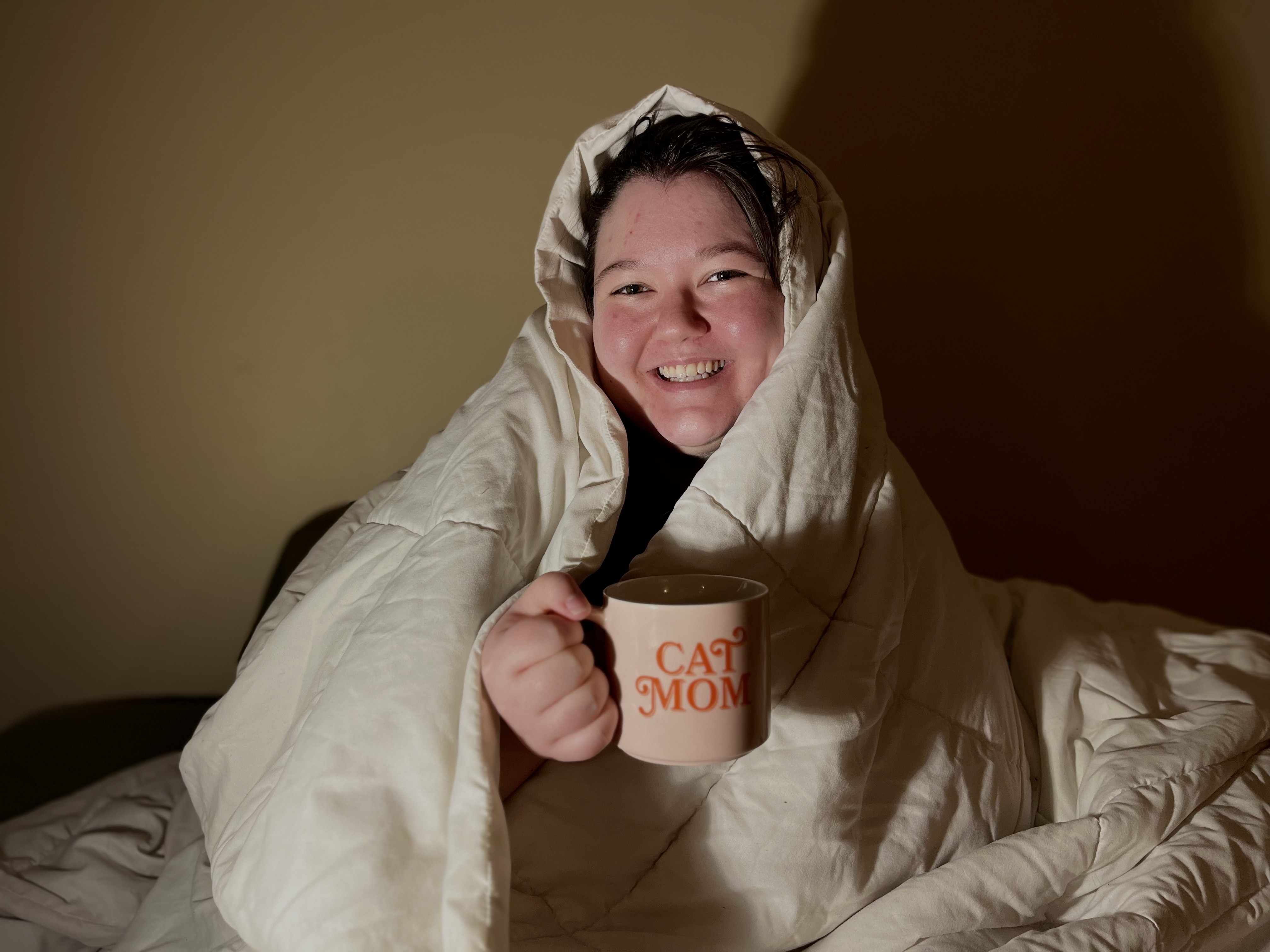 Jo bundled up with a warm drink.