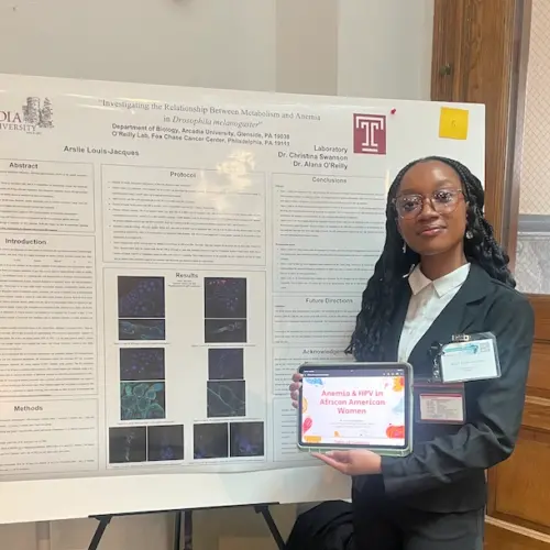 Arslie with her poster at the symposium.