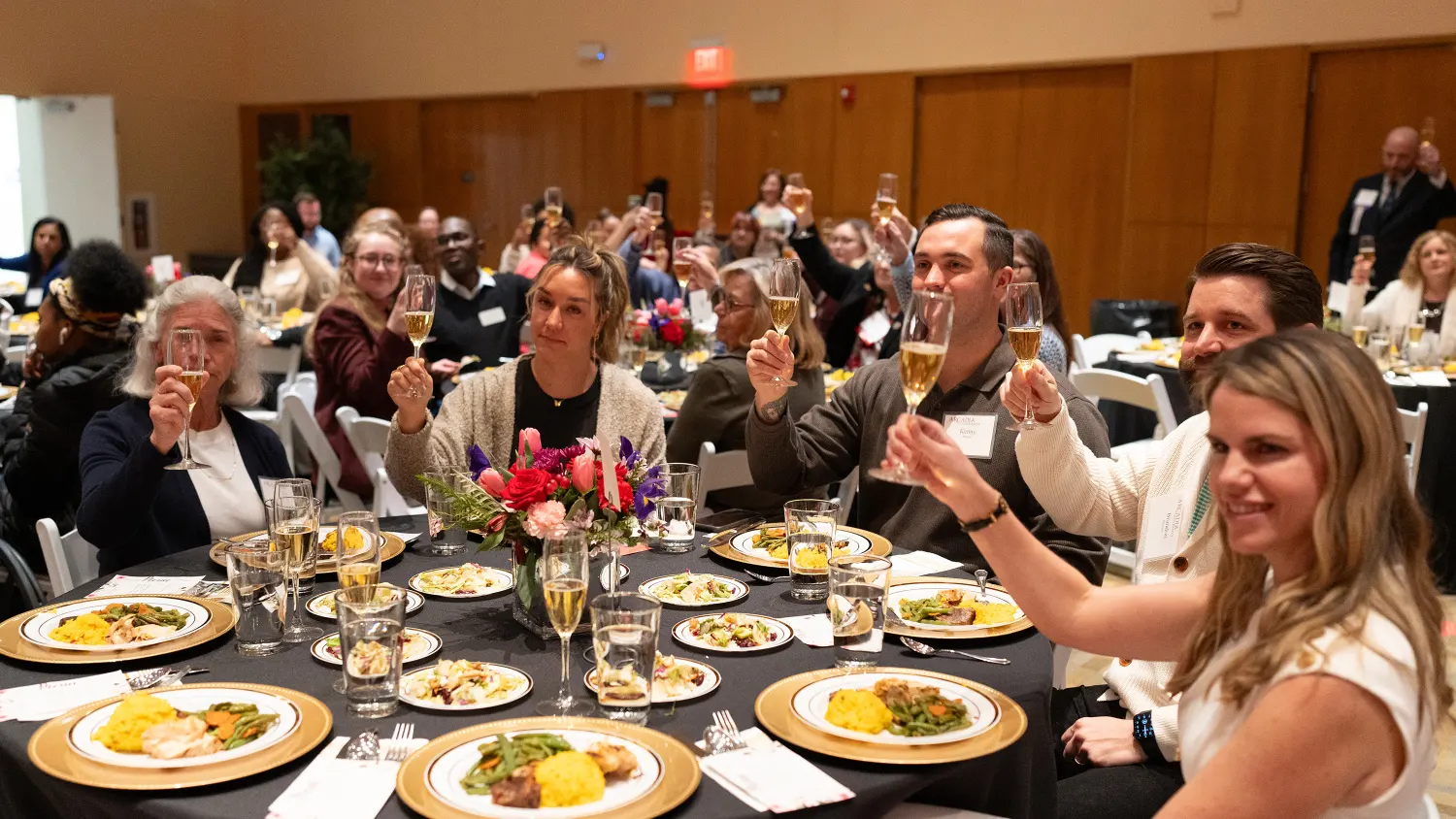A table of attendees have a toast during the Women Who Lead Forum 2024 event.