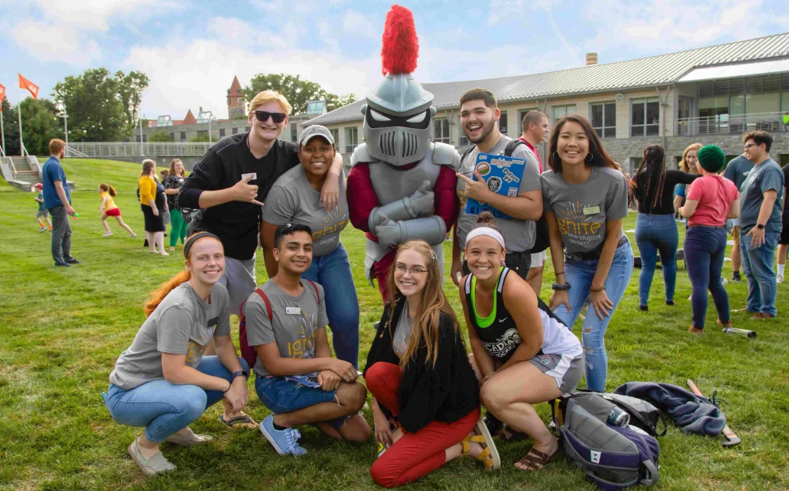 students pose with Archie the Knight, Arcadia's mascot, on Haber Green