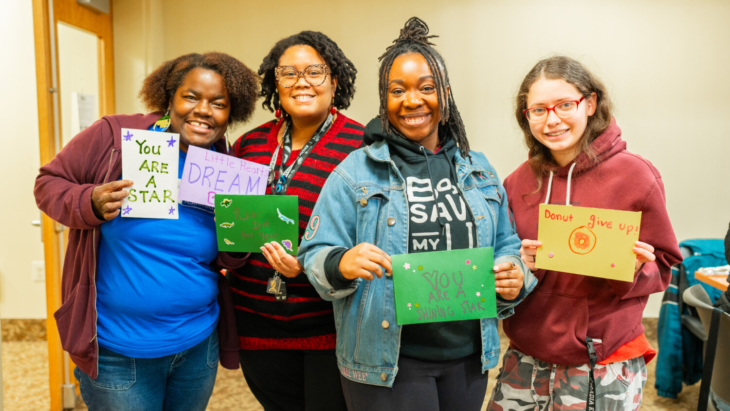 Four students showing their cards creating on Martin Luther King Jr. Day