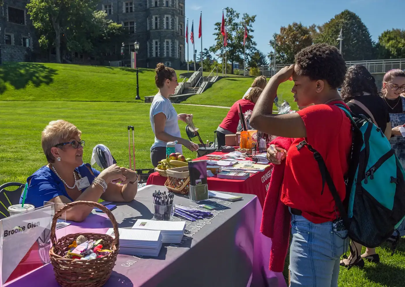 A student talks to a Counseling Services staff member during an outdoor wellness fair.