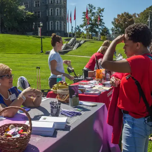 A student talks to a Counseling Services staff member during an outdoor wellness fair.