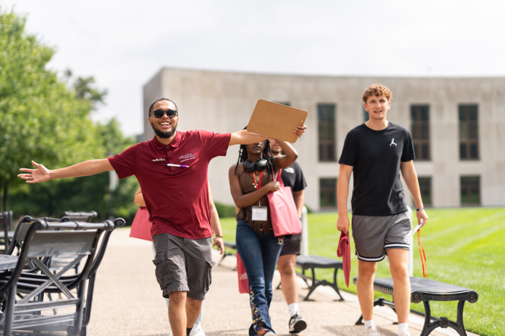 An Arcadia staff members welcomes students on campus with a tour.