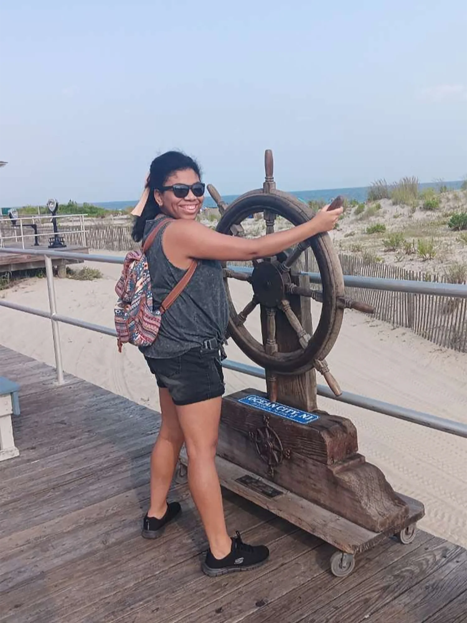 Zoe McNair posing with a fake prate ship steering wheel on the boardwalk.