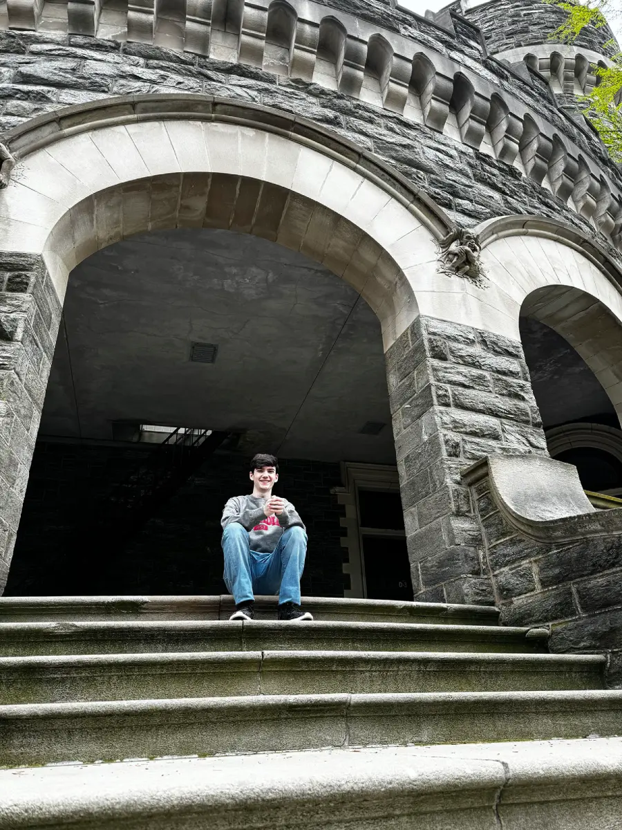 Juno Teller sitting on the steps of Arcadia's Grey Towers Castle.