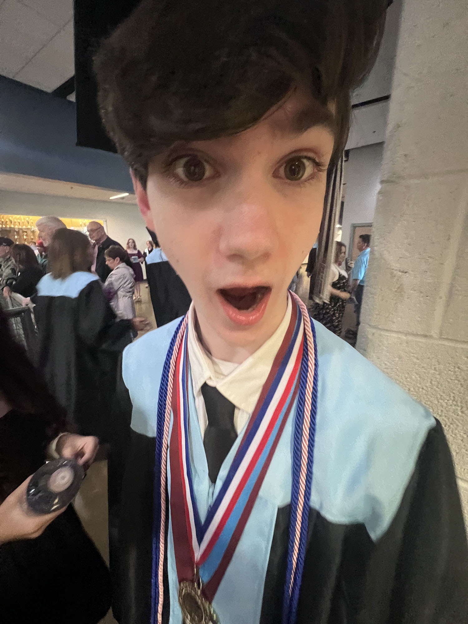 Juno Teller with a surprised face at his high school graduation.