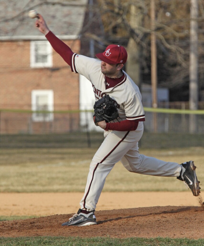 Adam Planamento pitching a baseball during a game as an undergraduate student at Arcadia. In white and red uniform