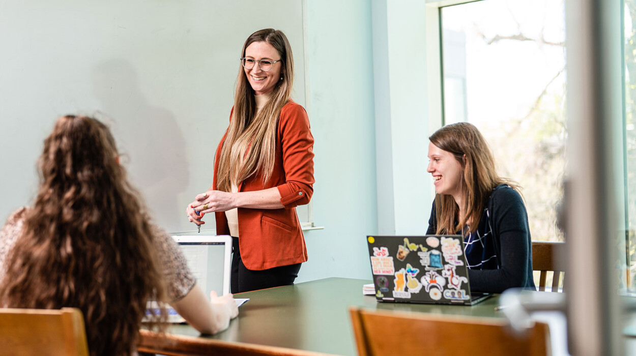 A professor giving a lecture with two engaging students