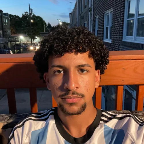 Ian Catalino-Vasquez ’28 sitting on a porch at night.